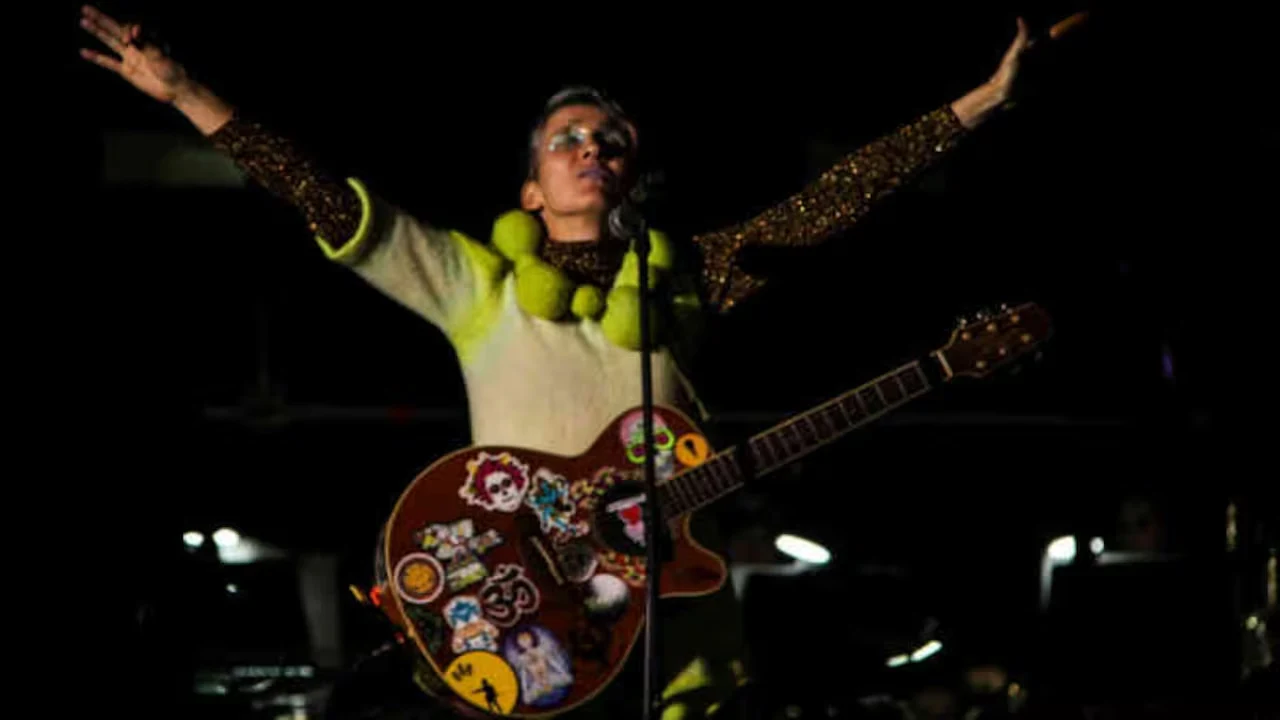 Andrea Echeverri canta con una guitarra y los brazos abiertos