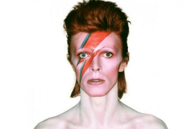 David Bowie en primer plano, ícono de la cultura pop y figura central del posthumanismo sónico.