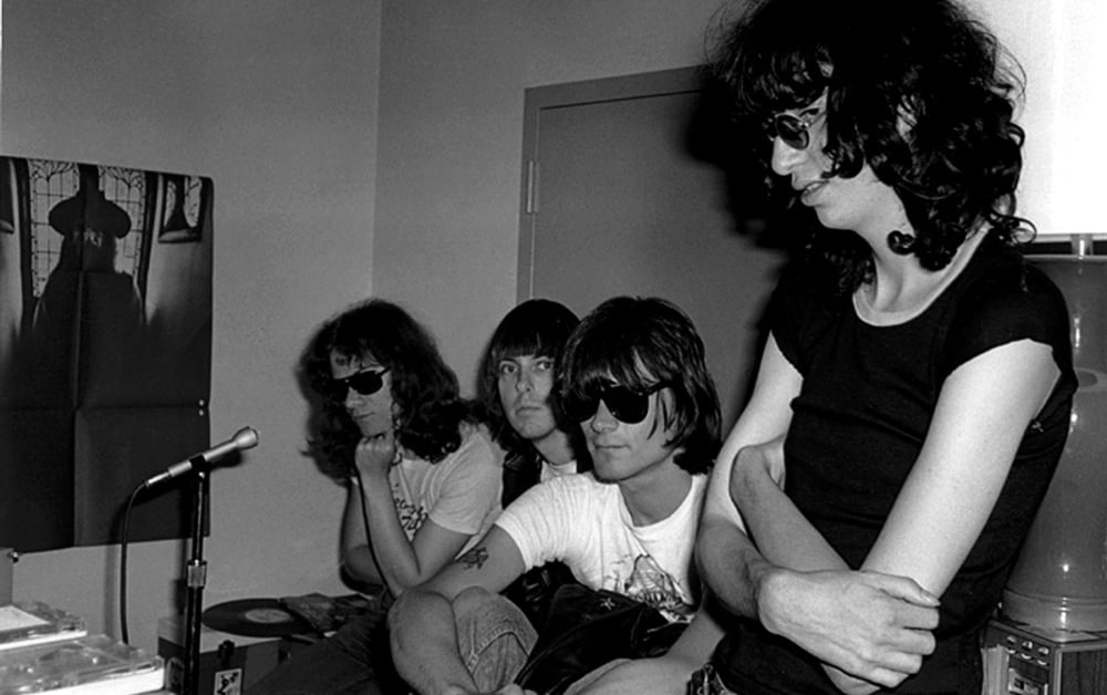 The Ramones en blanco y negro, sentados en una sala pequeña con gafas oscuras, escena del documental 'End of the Century'