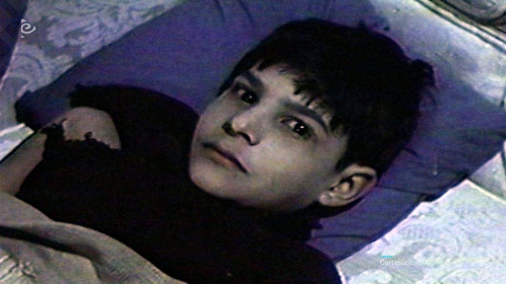 Niño acostado con mirada fija en un fotograma de 27 horas con la muerte (1981) de Jairo Pinilla.