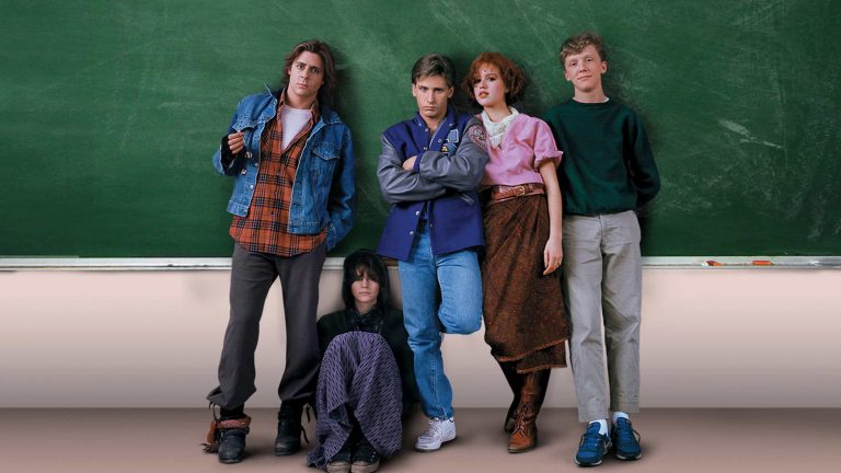Personajes principales de El club de los cinco posando frente a un tablero verde en la escuela.