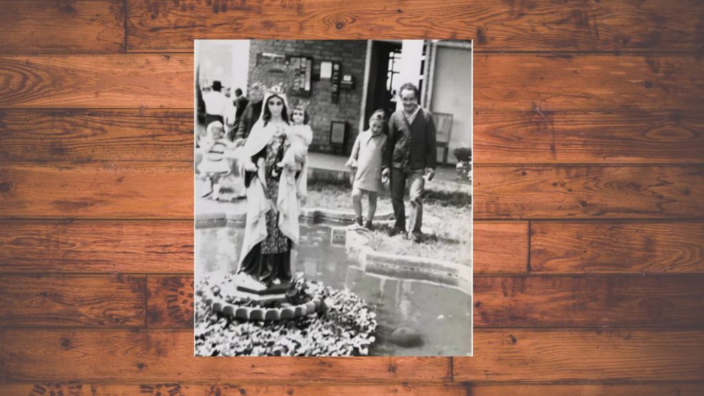 José Armando Alfaro con su hija Sandra (9 años) frente a una fuente con la imagen de la Virgen del Carmen que él ayudó a construir, durante su trabajo en carreteras.