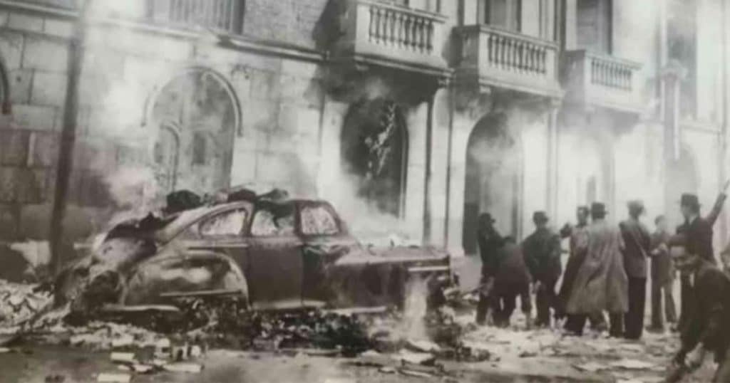 Fotografía histórica del Bogotazo tras el asesinato de Jorge Eliécer Gaitán el 9 de abril de 1948, con un automóvil incendiado y manifestantes en una calle del centro de Bogotá.