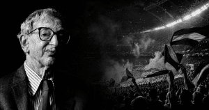 Retrato en blanco y negro de Eric Hobsbawm junto a una tribuna llena de hinchas con banderas en un estadio, en una imagen sobre fútbol, nación e identidad colectiva.