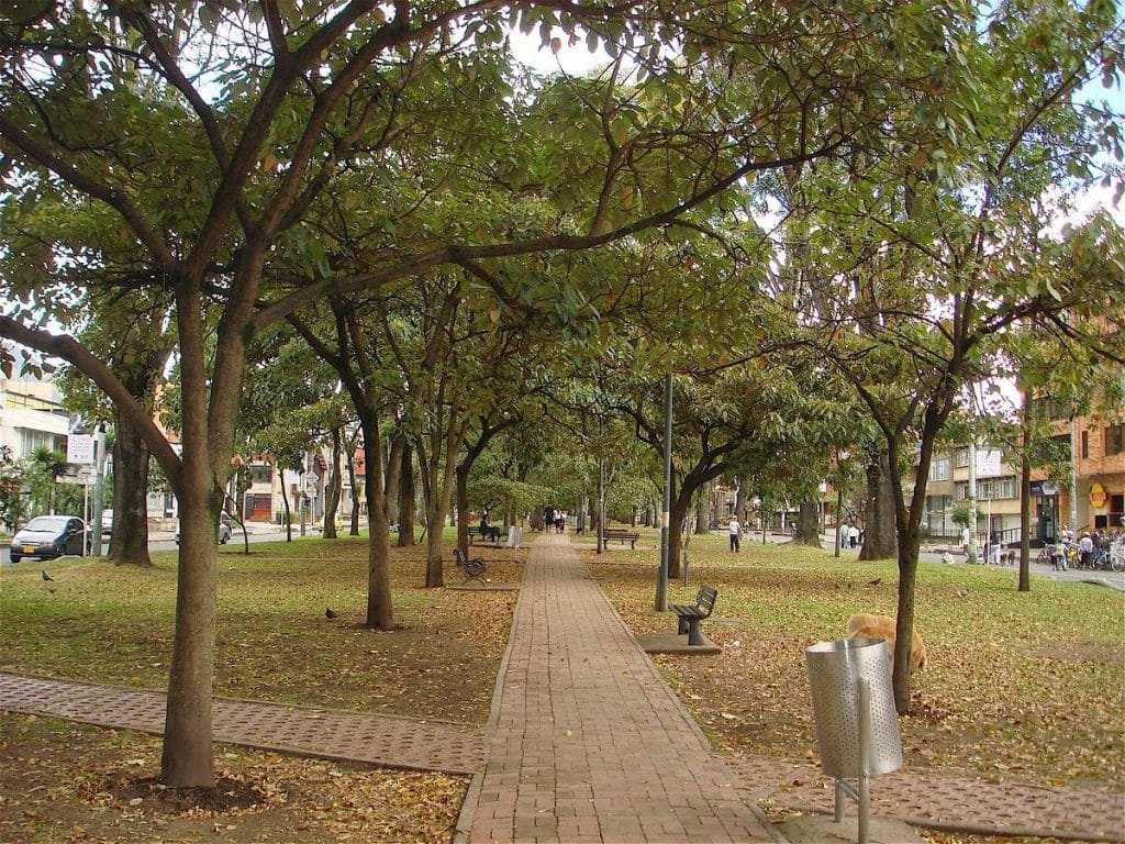 Sendero arbolado con caminería en ladrillo en Park Way, el parque lineal dentro del barrio La Soledad, Bogotá